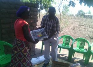 The GILEP Director hands over a sewing machine to Rose Patrick, Village Headwoman Namate.